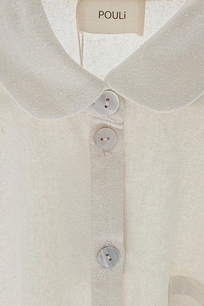 Close-up of a linen blouse collar with shell buttons on a set-in placket.