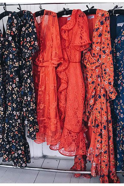 A garment rail in the J&O Studio workroom, hung with finished pieces.